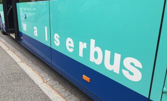 A bus with the inscription "walserbus" on the side. The colors are turquoise and blue. | © Kleinwalsertal Tourismus