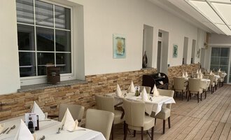 An elegant restaurant with wood-paneled walls and lovingly set tables. Large windows provide plenty of daylight and a pleasant atmosphere. | © Ristorante Trentino | Dietmar Jochum
