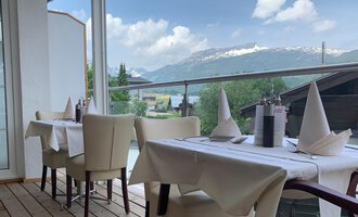 Ein einladendes Restaurant mit einem gemütlichen Außenbereich. Die Tische sind elegant gedeckt und bieten einen Blick auf die Berge. | © Ristorante Trentino | Dietmar Jochum