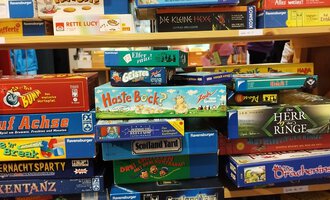 A shelf with various board games. The games are colorful and sorted in a diverse way. | © Kleinwalsertal Tourismus | N. Lughammer