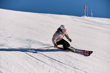 Woman skiing on snow, wearing a protective helmet and sports clothing, using skis for downhill skiing. | © Kleinwalsertal Tourismus eGen • Photographer: Oliver Farys