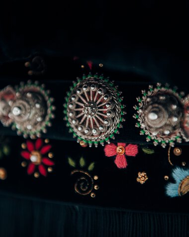 Close-up of a traditional costume belt with ornate buckle and floral embroidery. | ©  Kleinwalsertal Tourismus eGen • Photographer: Stefan Klauser