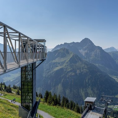 Panoramaaussicht vom Walmendingerhorn mit Bergpanorama im Sommer, inklusive Aussichtsplattform und Seilbahn. | © Kleinwalsertal Tourismus eGen • Fotograf: Steffen Berschin