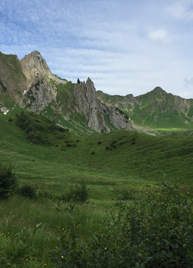 Green meadows in Bärguntal with mountains in the background, cloudy sky, summer in Kleinwalsertal. | © Kleinwalsertal Tourismus eGen