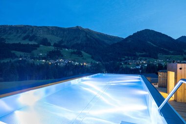 Ein beheizter Außenwhirlpool auf einer Terrasse mit Blick auf Berge bei Sonnenuntergang, Teil des Wellnessbereichs im Hotel Sonnenburg. | © Hotel Sonnenburg